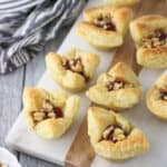 Strawberry Balsamic Baked Brie Bites feature just five ingredients! This appetizer recipe includes creamy brie cheese in mini puff pastry cups with a sprinkling of walnuts and a strawberry balsamic topping. These bites are an individually-sized way to enjoy the traditional baked brie en croute.