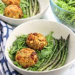 Sun-dried tomato and pesto tuna cakes are a flavorful, healthy meal that comes together quick enough for a weeknight dinner recipe. These tuna cakes are baked and served over a bed of arugula and alongside easy pan-roasted asparagus.