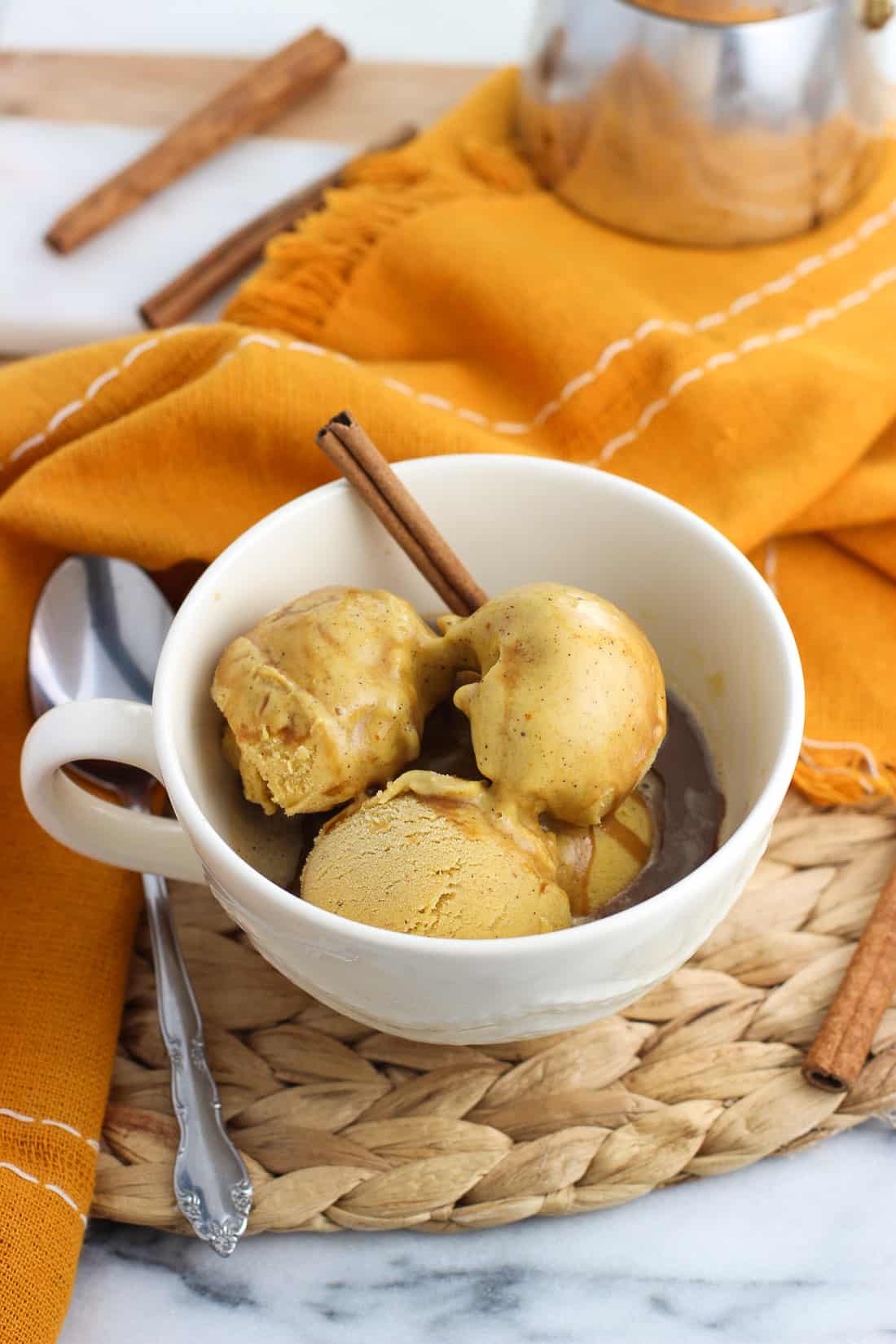 Hot espresso poured over scoops of pumpkin ice cream in a mug to slowly melt it