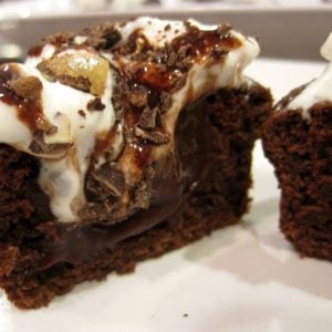 A filled chocolate cupcake cut in half on a plate.