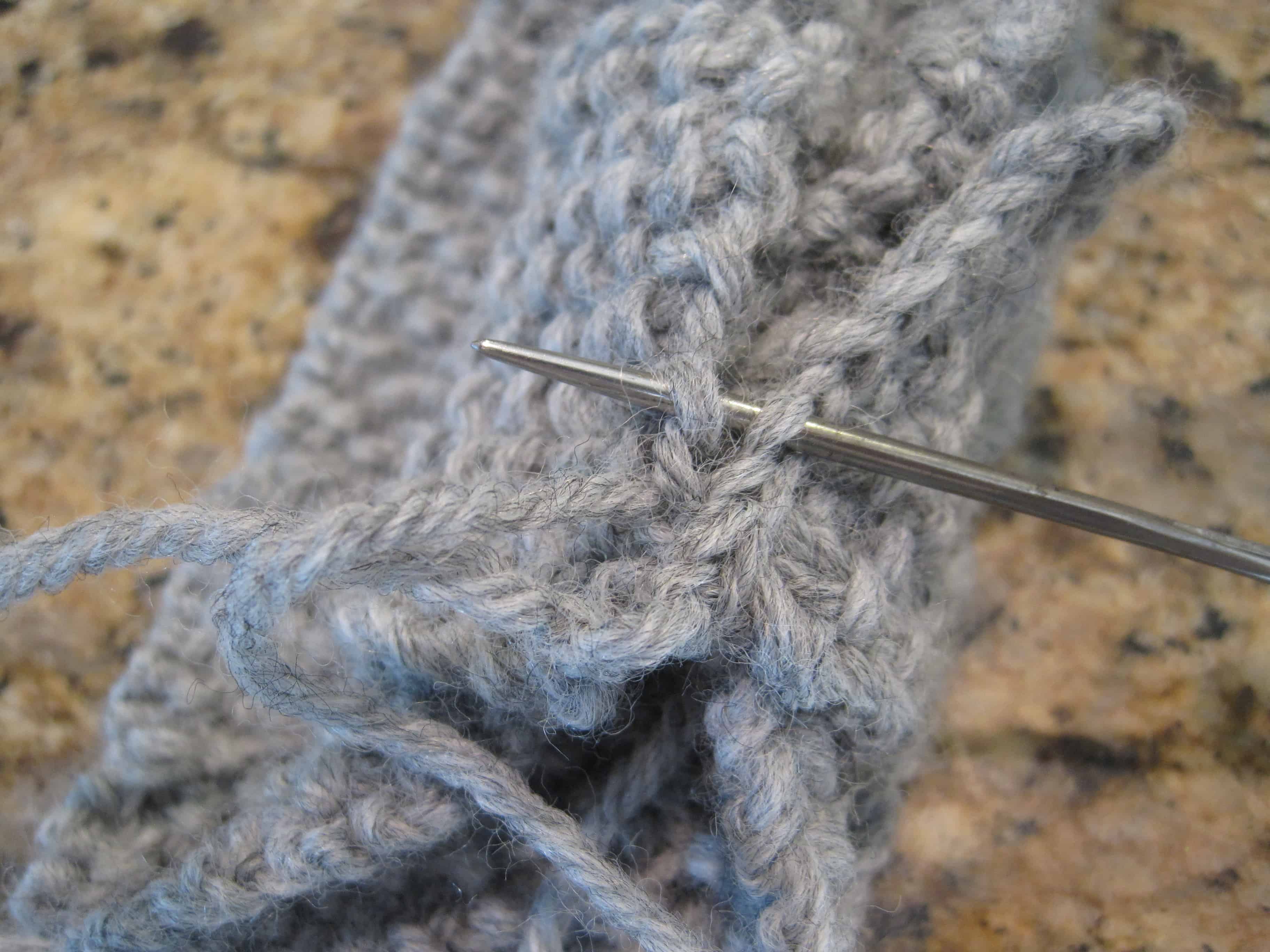 A needle joining two sections of a knit headband.