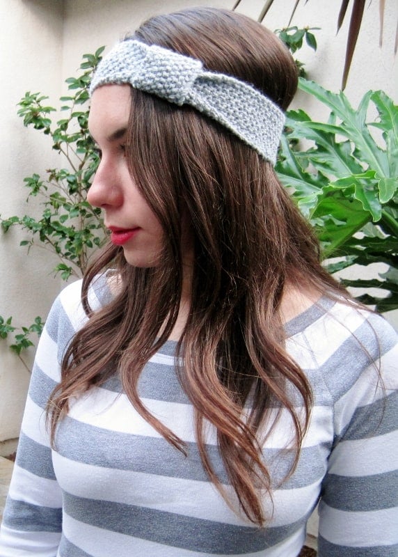 A woman looking to the side wearing a knit headband.