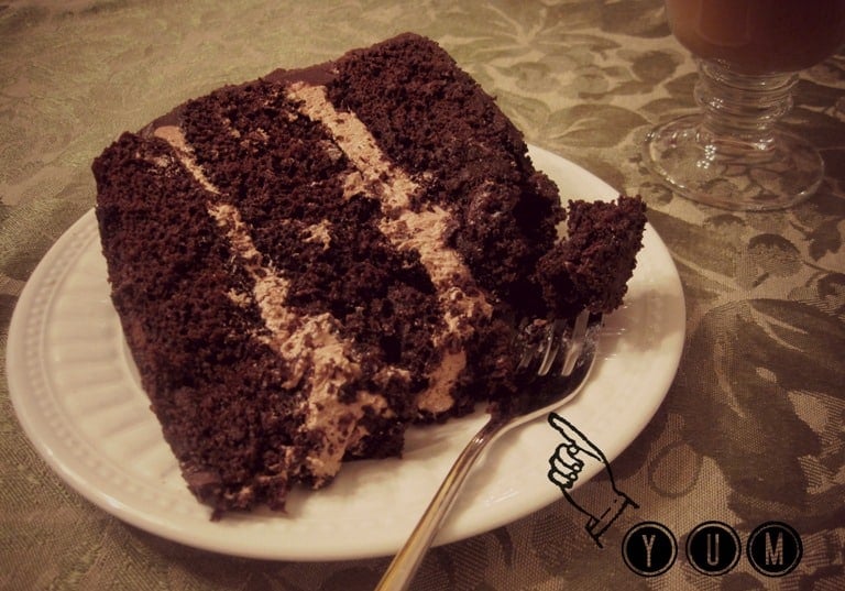 A large slice of cake on a dessert plate with a fork.