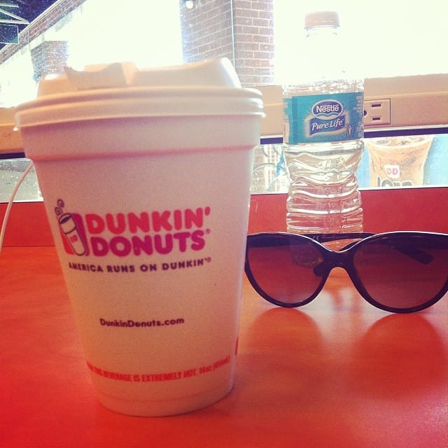 Dunkin Donuts coffee cup with a water bottle and sunglasses.