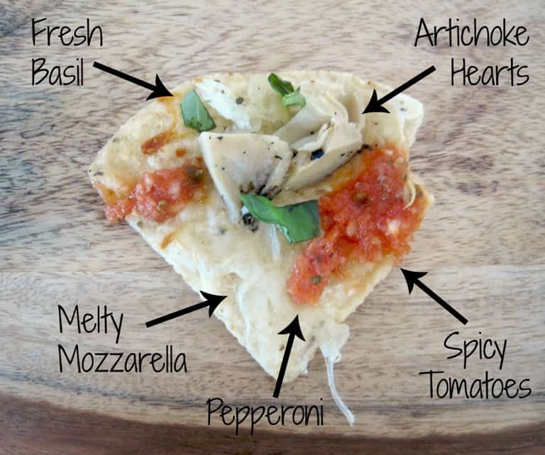 A loaded nacho with text overlay pointing out the various toppings.