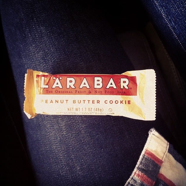 A wrapped Larabar sitting on a person's leg.