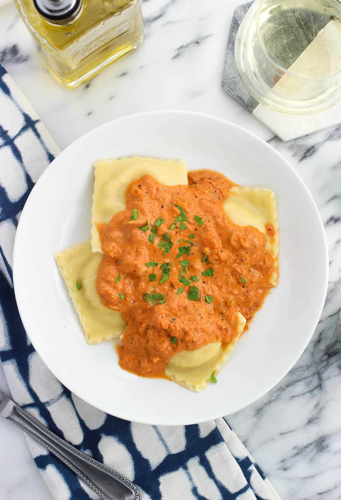 A serving of vodka sauce over ravioli in a shallow bowl.