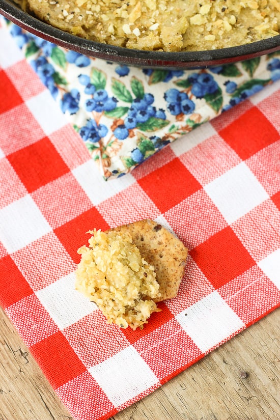 Dip spread onto a cracker on a napkin near the dish.