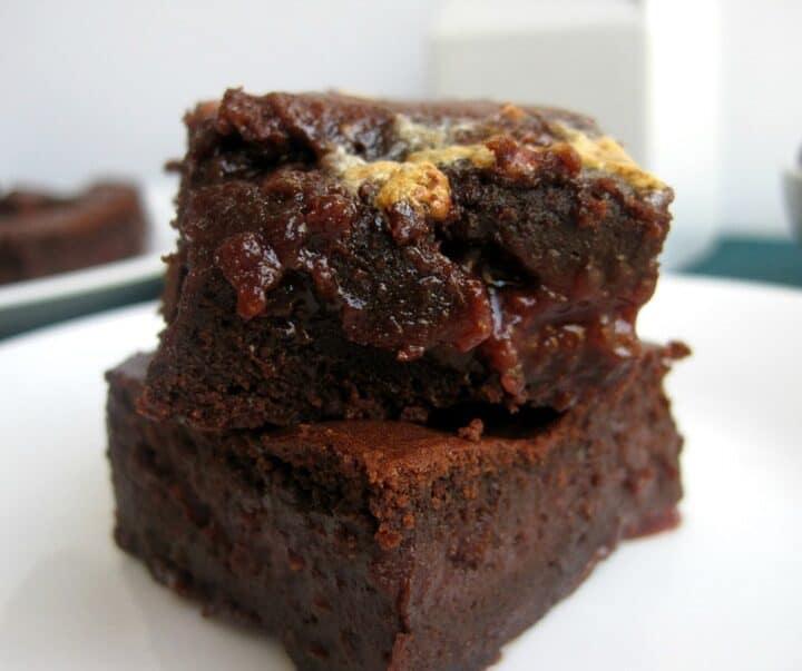 A stack of two brownies on a plate.