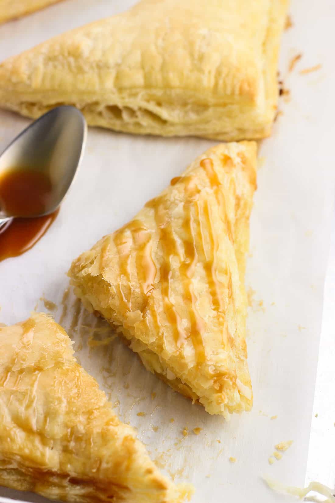 A flaky turnover cut in half and drizzled with caramel sauce