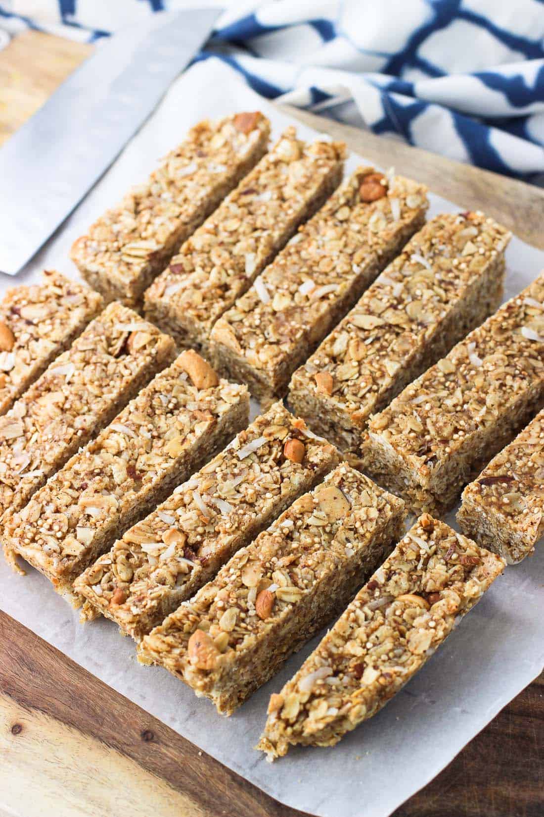 Twelve granola bars just after being sliced on the cutting board