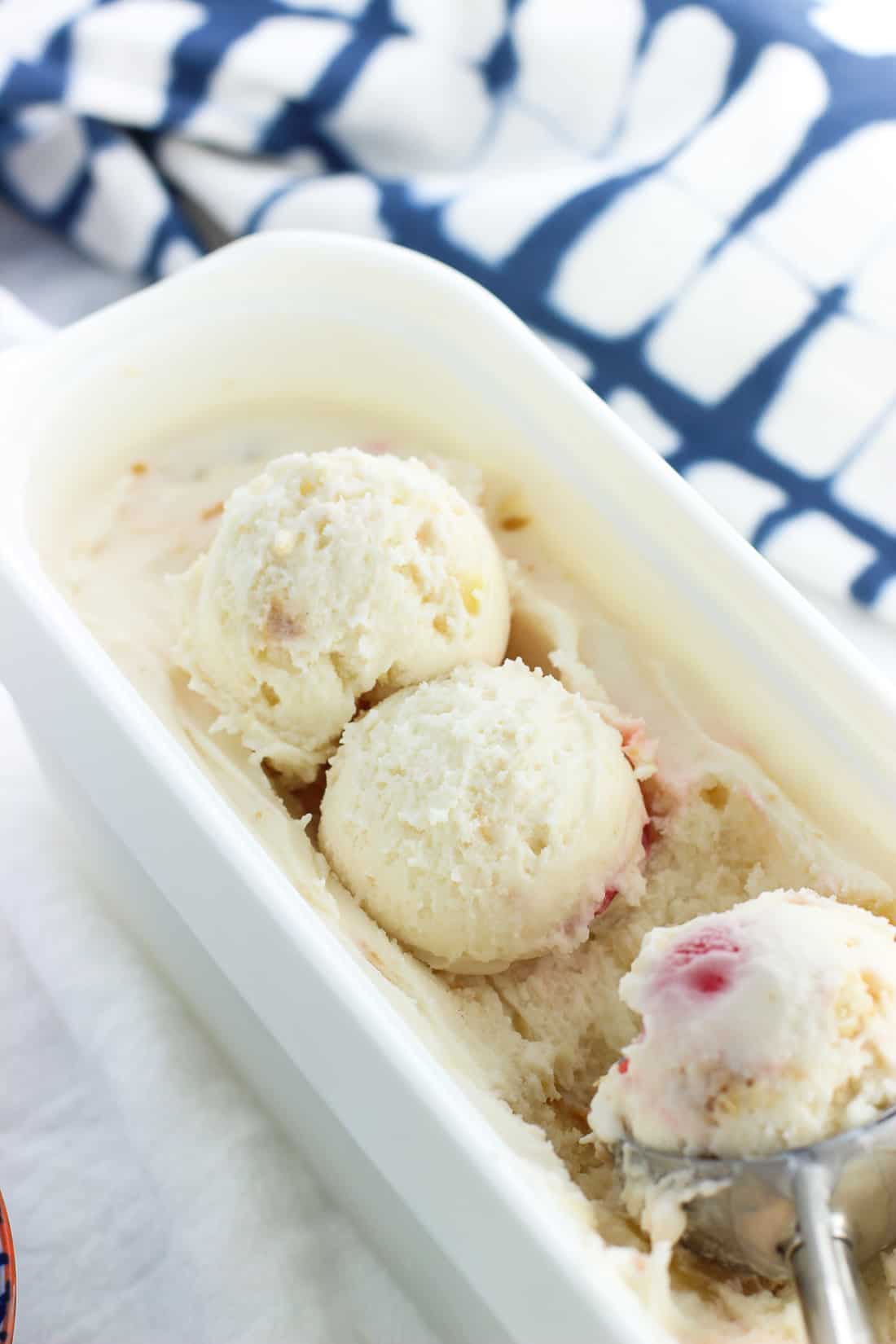 Round scoops of frozen yogurt on the surface of the full container.