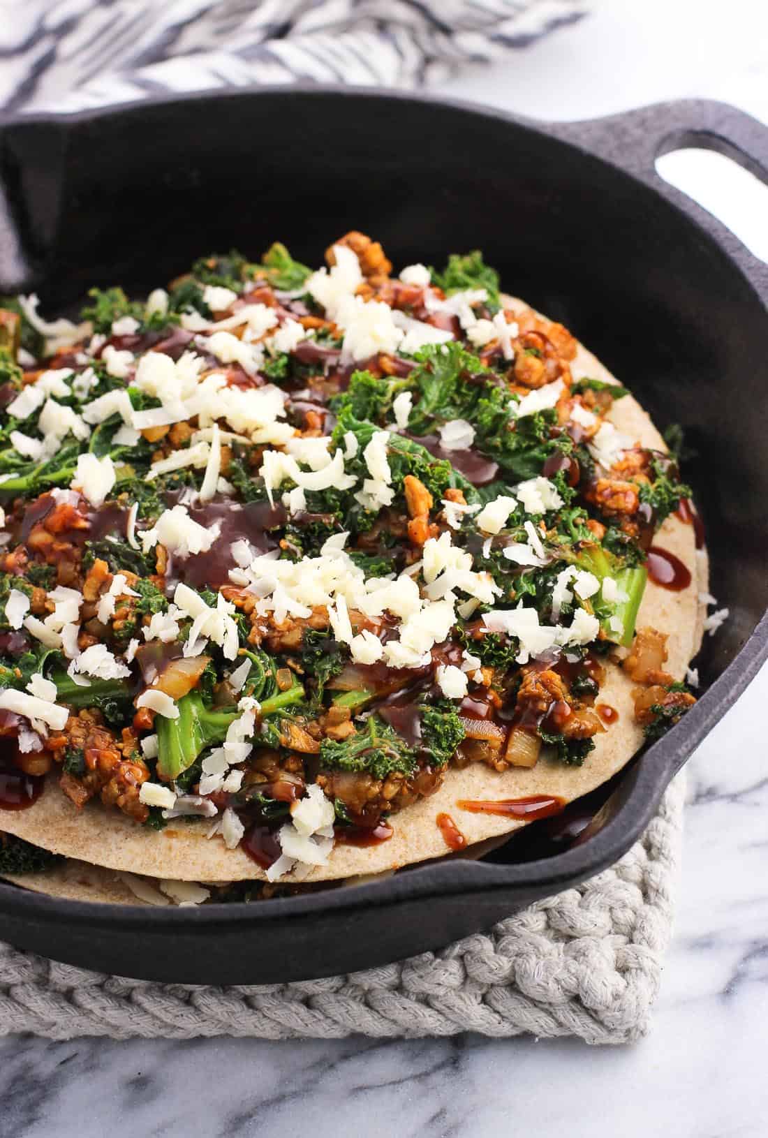 The tempeh pie halfway through being assembled in a round cast iron pan.