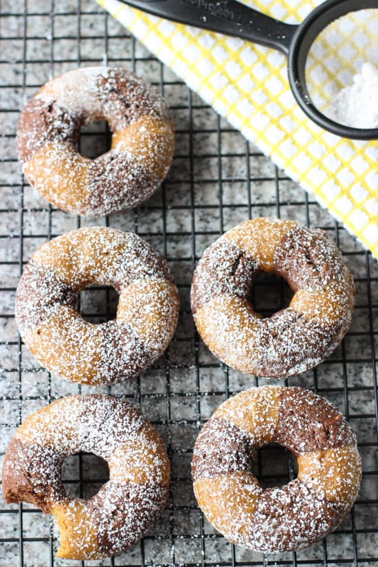 An overhead view of five donuts on a wire rack.