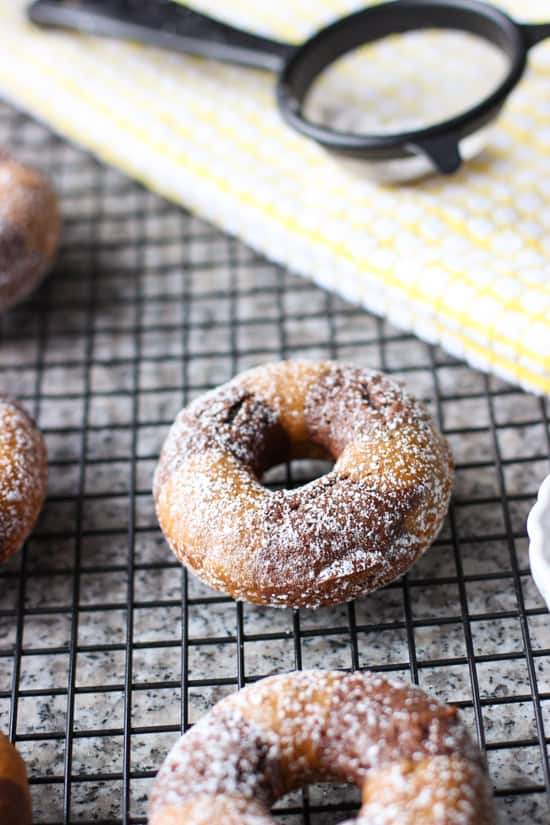 A doughnut sitting on top of a metal rack.