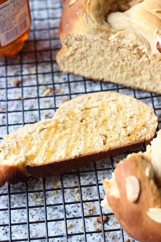 A close-up of a slice of bread on a wire rack drizzled with honey