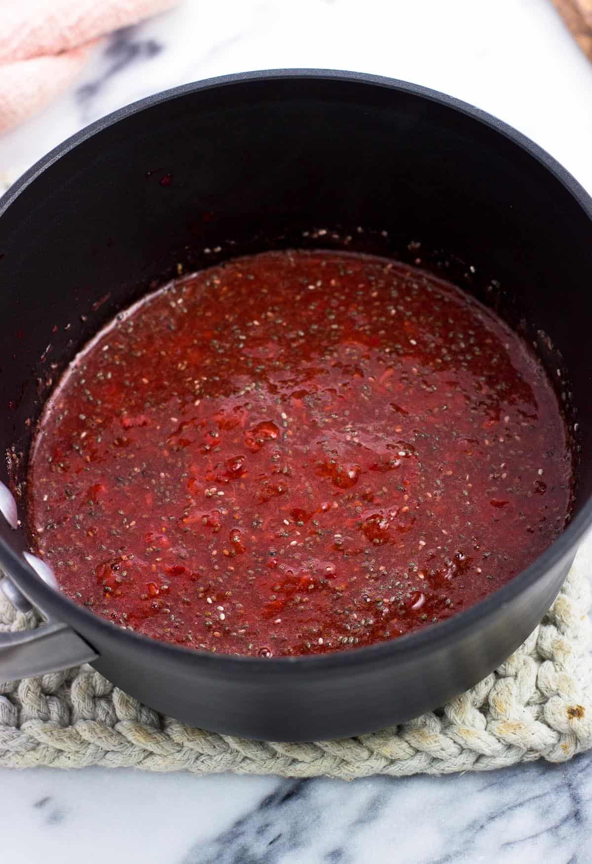 Strawberry jam in the saucepan after stirring in all ingredients.