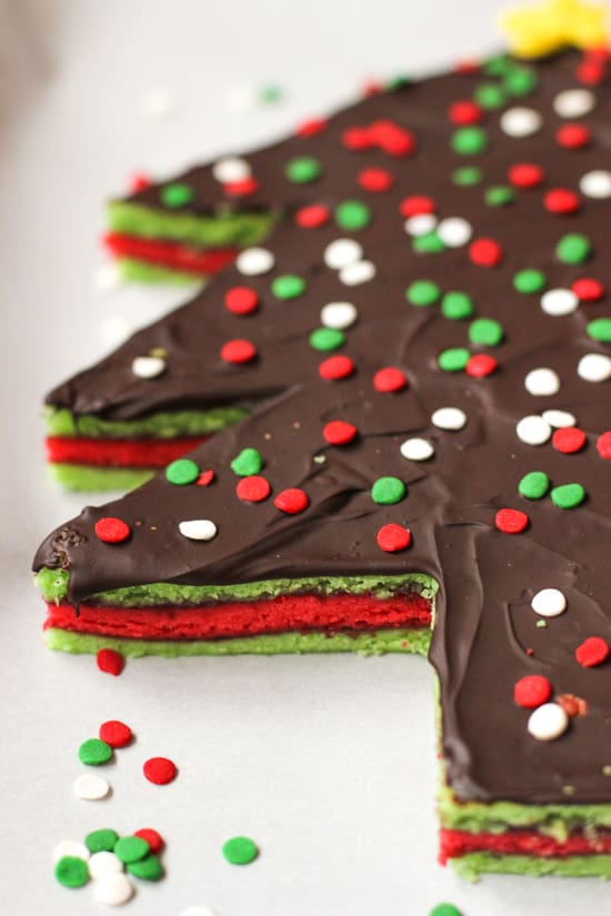 A side-view of Christmas tree rainbow cookie cake.