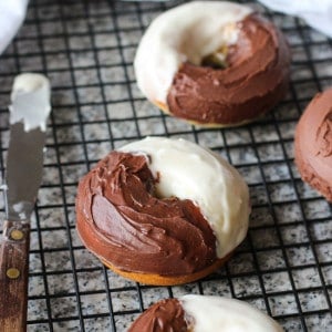 Iced black and white donuts on a wire rack.