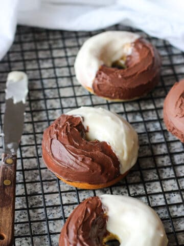 Iced black and white donuts on a wire rack.