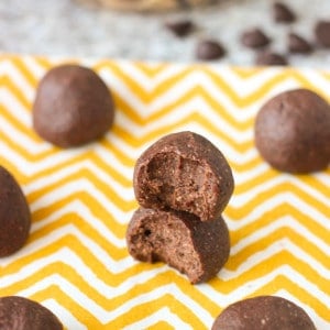 Two bitten trail mix bites on a table stacked on top of one another.