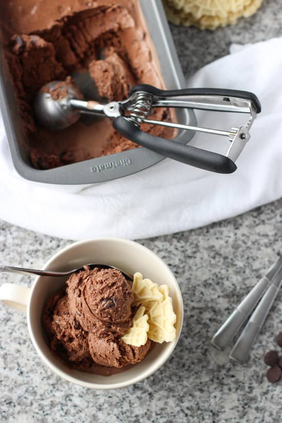 A bowl of ice cream in front of the ice cream container.