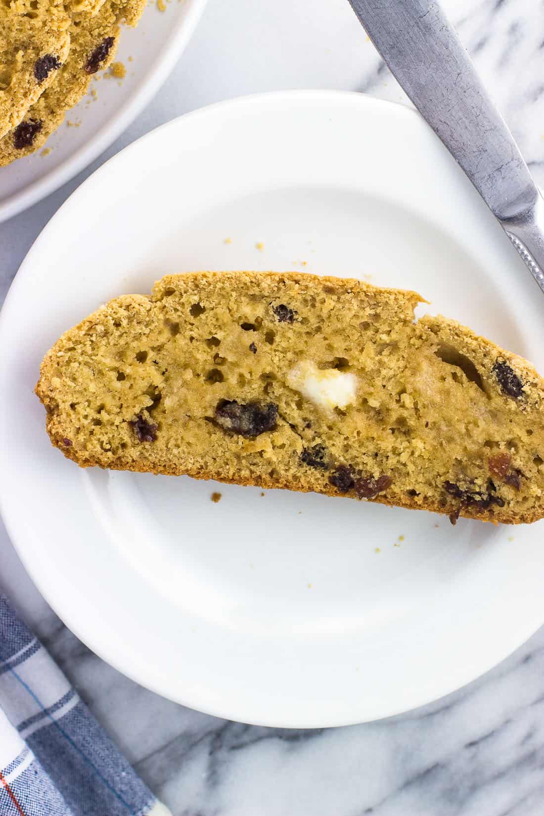 A slice of soda bread on a plate topped with melting butter.