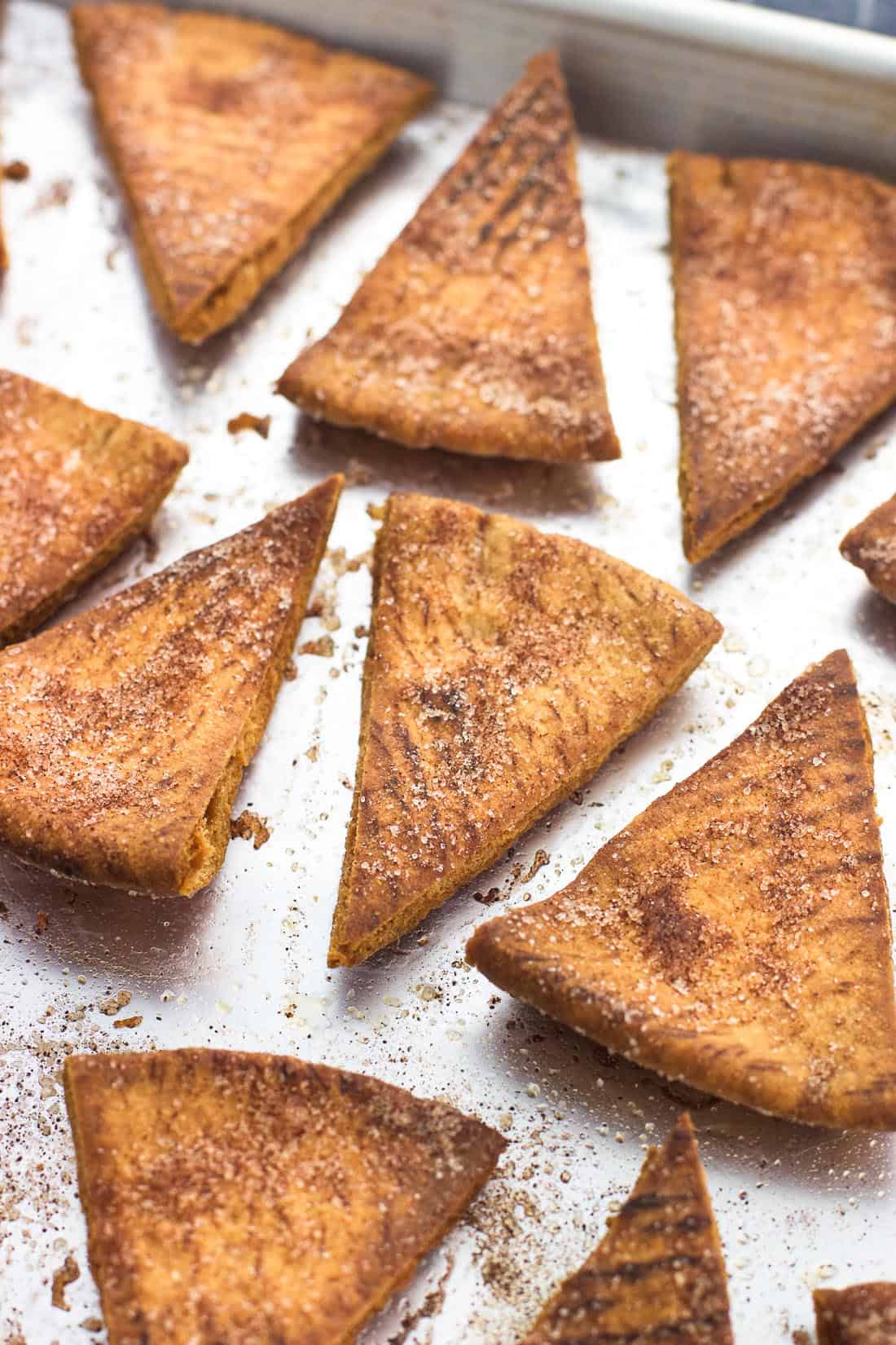 Baked cinnamon sugar pita chips on a foil-lined baking sheet