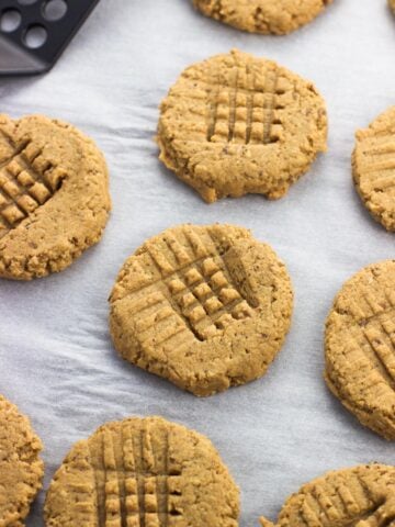 Peanut butter cookies on a sheet of parchment paper.