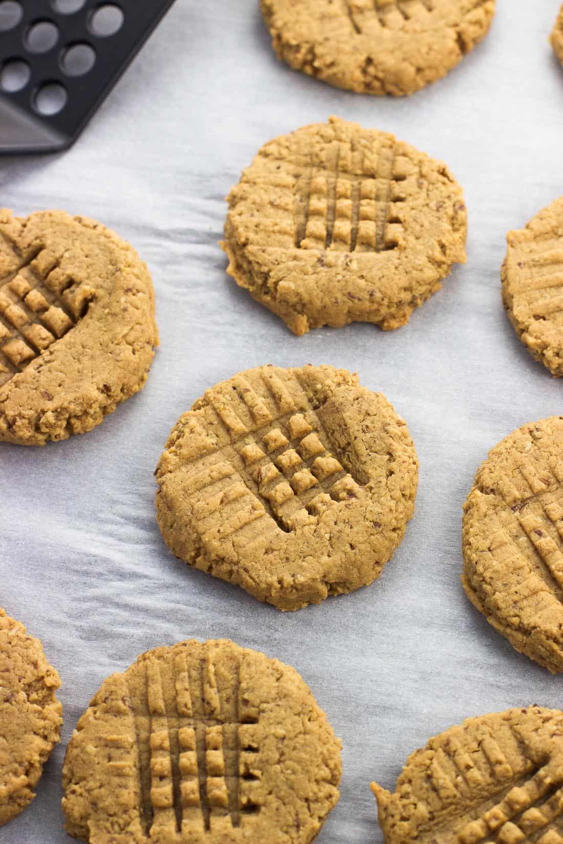 Peanut butter cookies on a sheet of parchment paper.