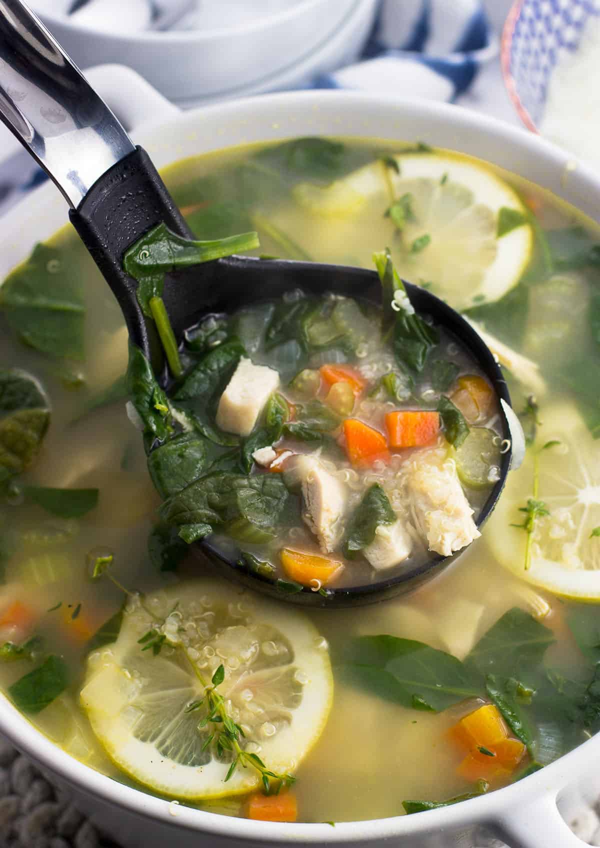 A ladle full of soup being lifted out of the pot of soup