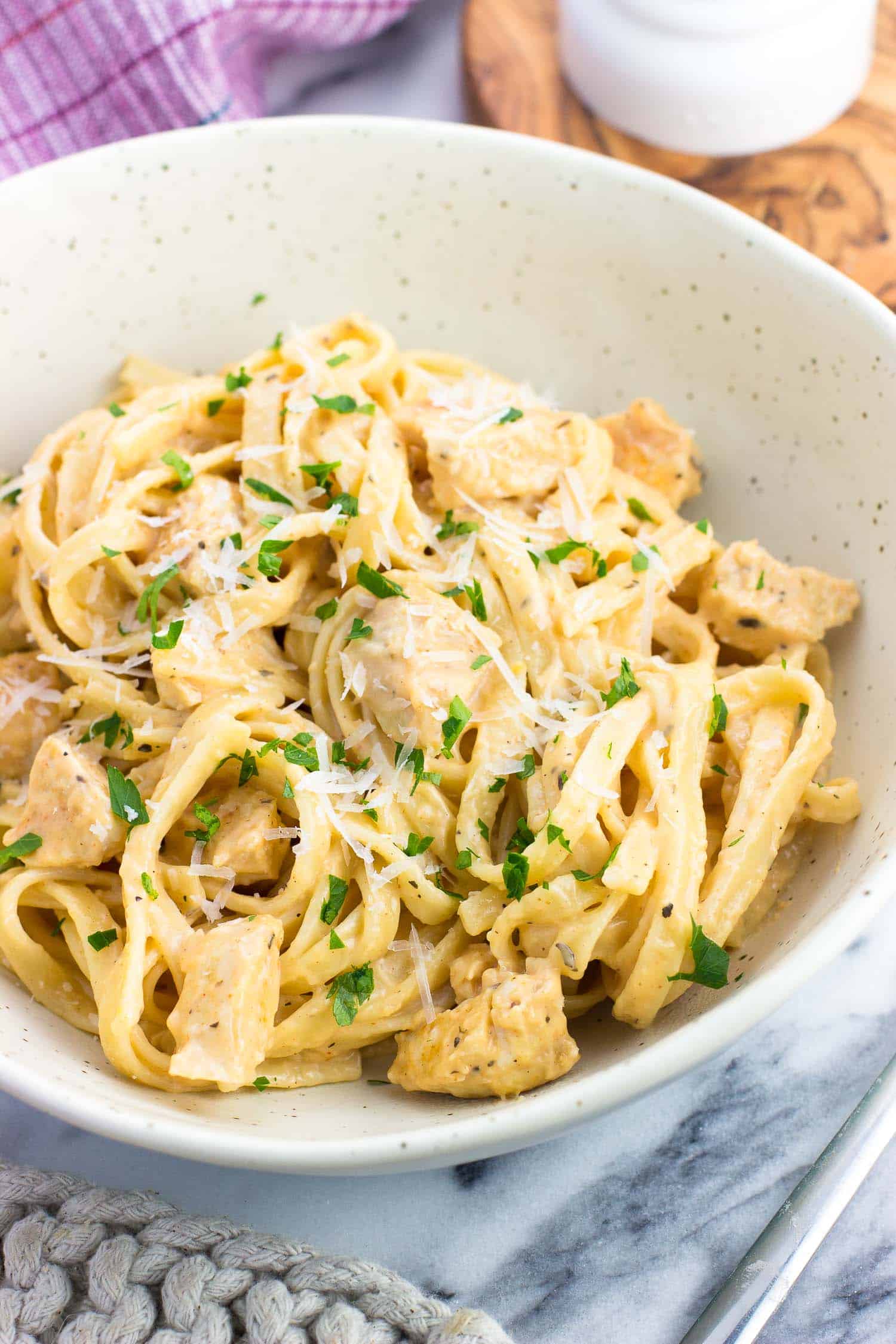 A plate of buffalo chicken alfredo pasta garnished with parsley.