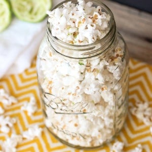 A clear glass jar overflowing with popcorn