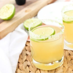 A beergarita in a rocks glass with a lime round and a lime and salt rim