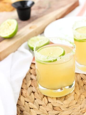 A beergarita in a rocks glass with a lime round and a lime and salt rim