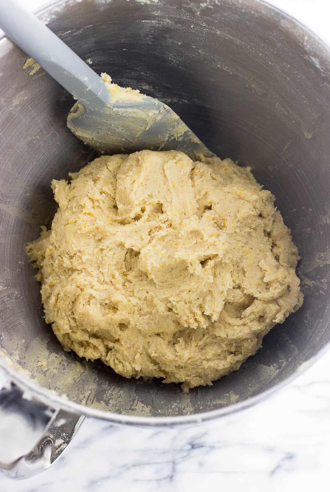 Cookie dough in a metal mixing bowl with a spatula ready to be chilled