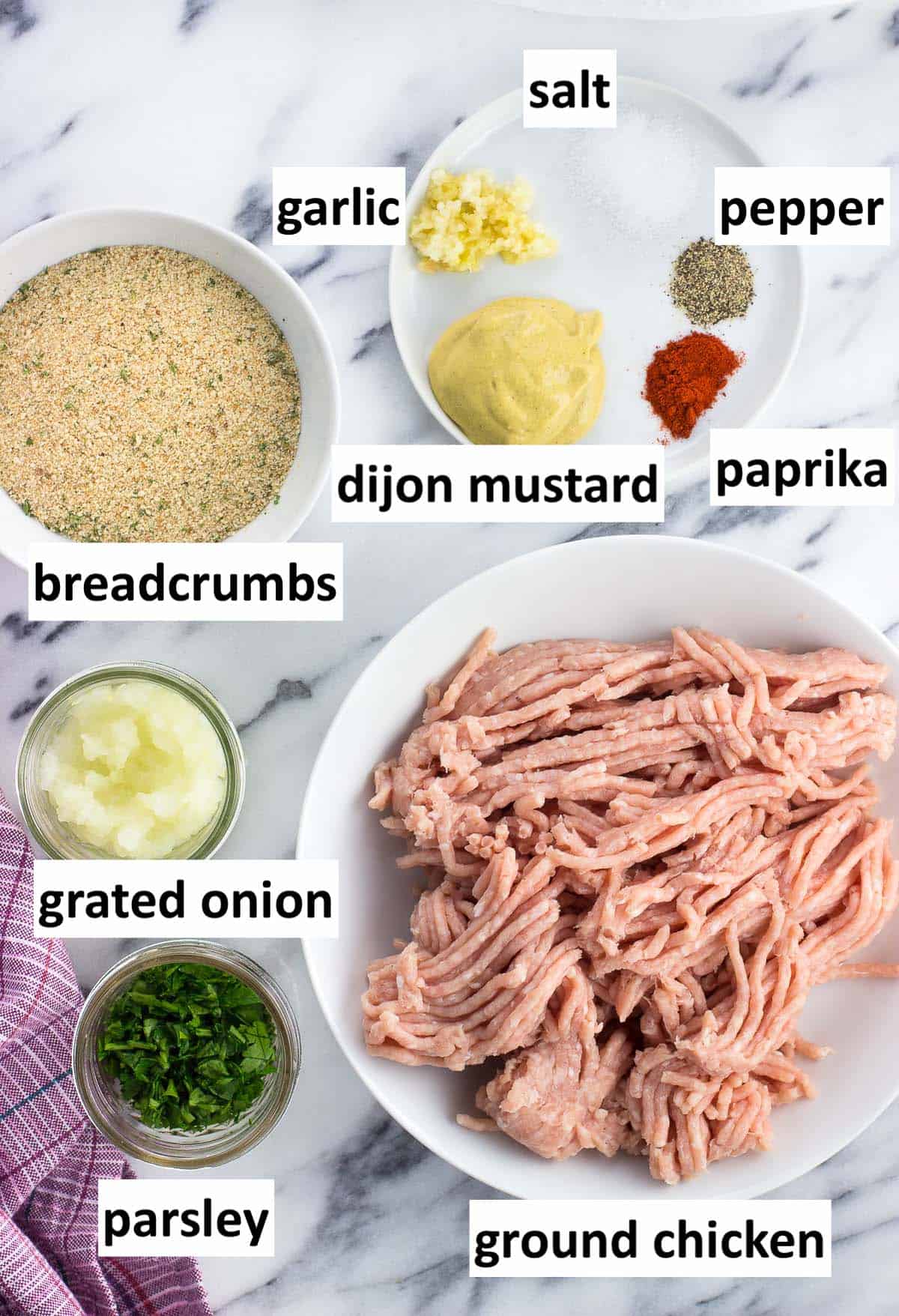 Recipe ingredients in separate bowls on a marble board.