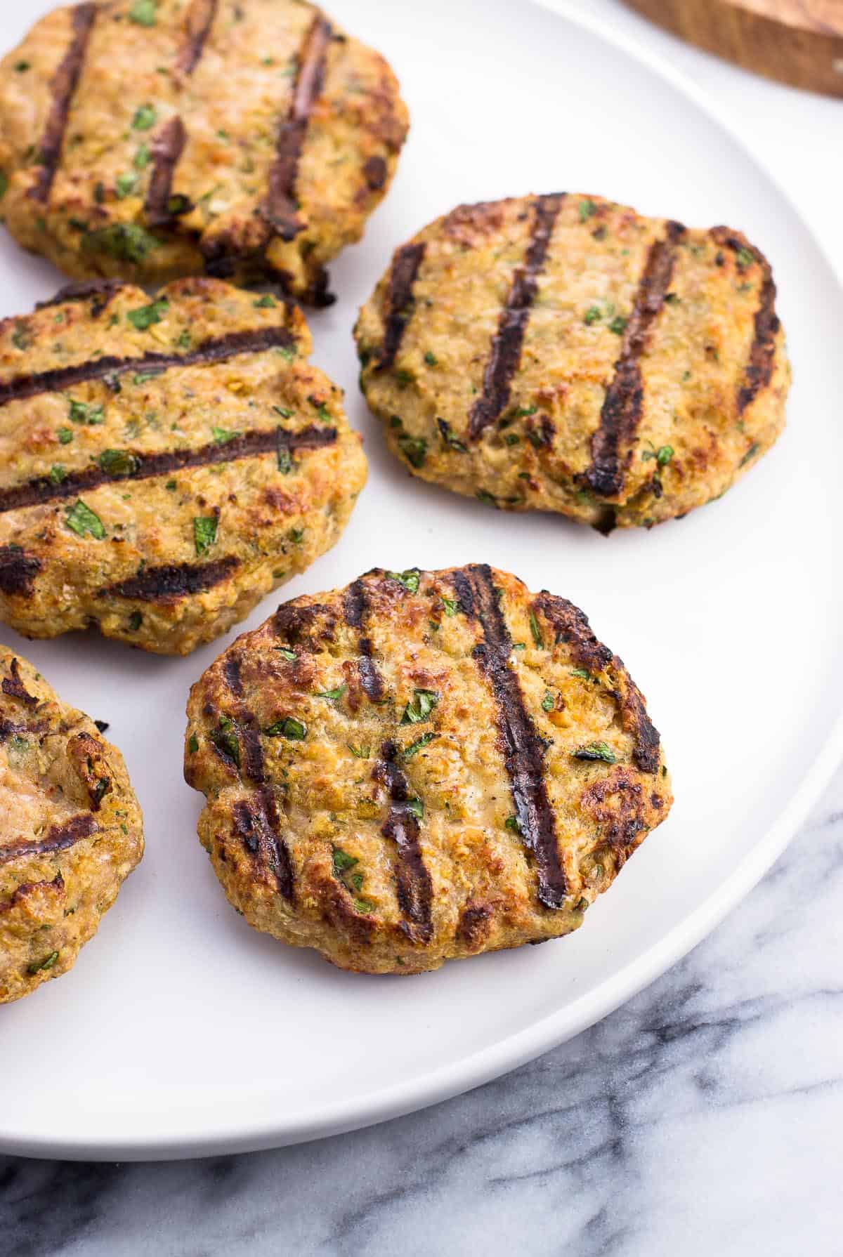 Grilled chicken burger patties on a plate.