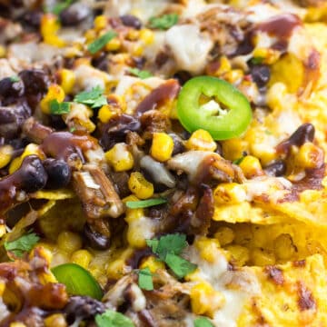 A close-up picture of pulled pork nachos on a sheet pan