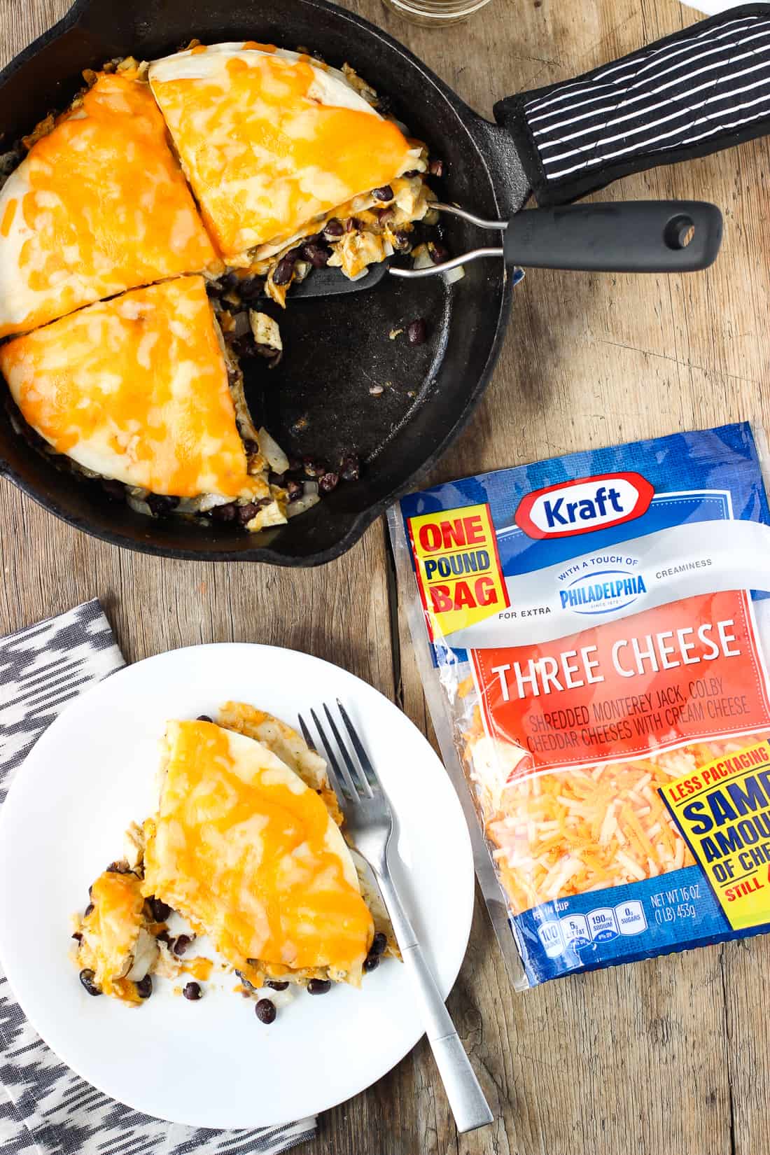 A wedge of tortilla pie taken out of the pan and put on a plate next to the bag of shredded cheese.