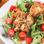Tuna cakes on a garden salad on a plate.