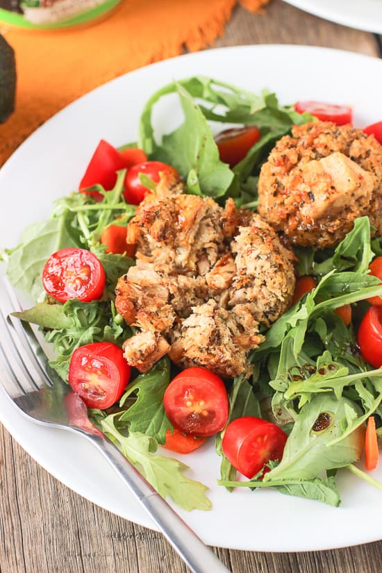 Tuna cakes on a garden salad on a plate.