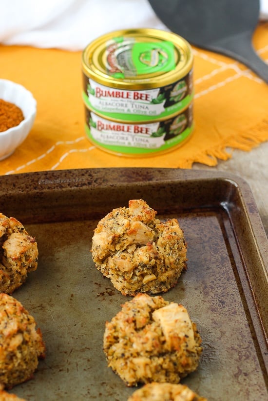 Tuna cakes on a metal baking sheet in front of cans of Bumble Bee tuna.