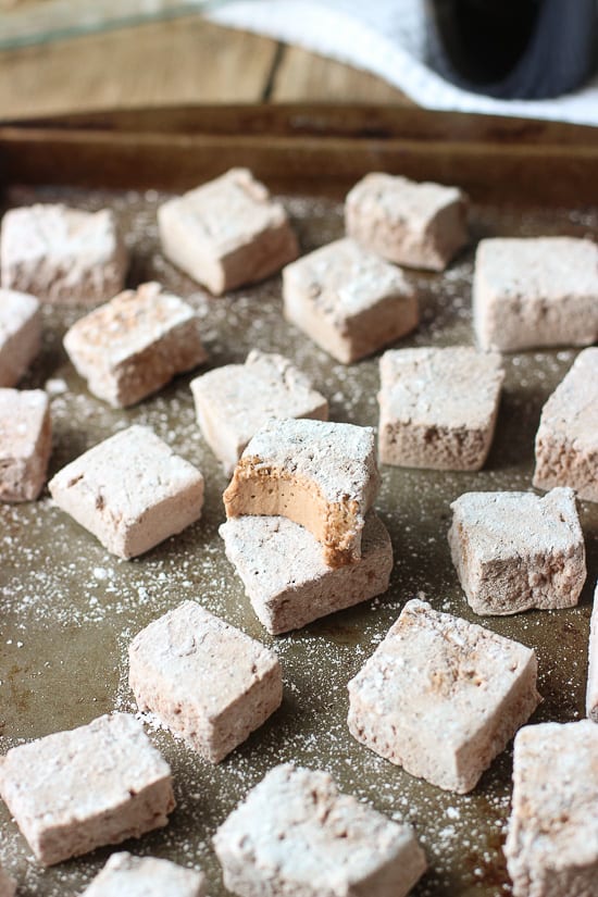 Marshmallows on a metal baking sheet with two stacked on top of one another.