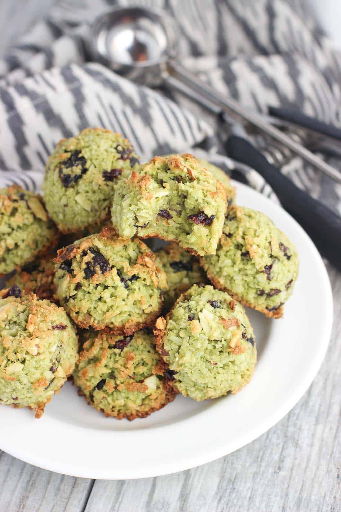 Macaroons piled on a plate with a bite taken out of the top one.