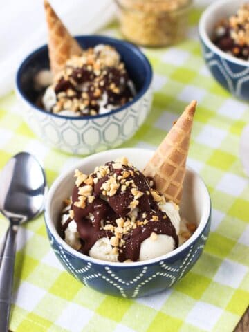 Ice cream sundaes in small bowls next to a spoon.