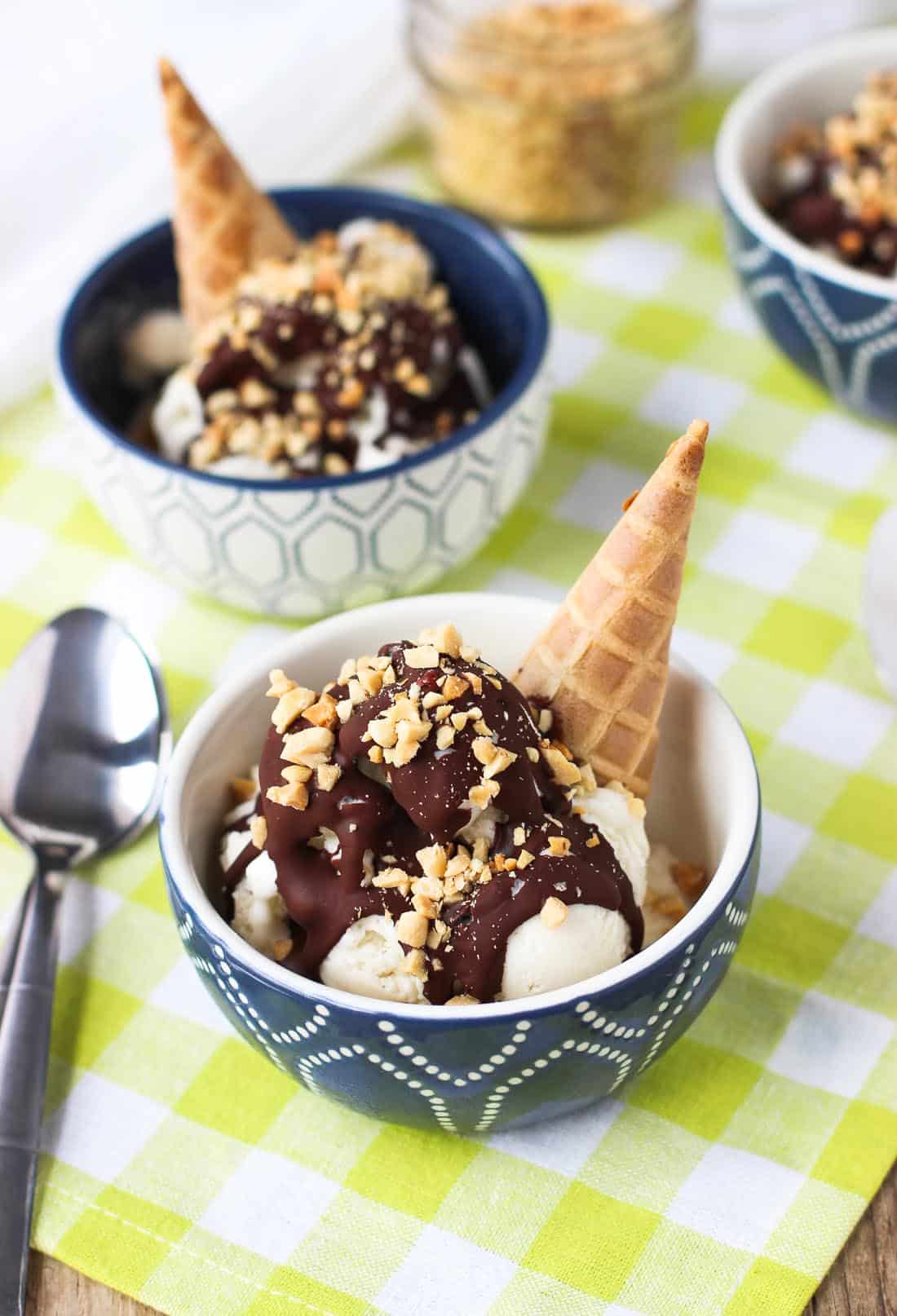 Ice cream sundaes in small bowls next to a spoon.