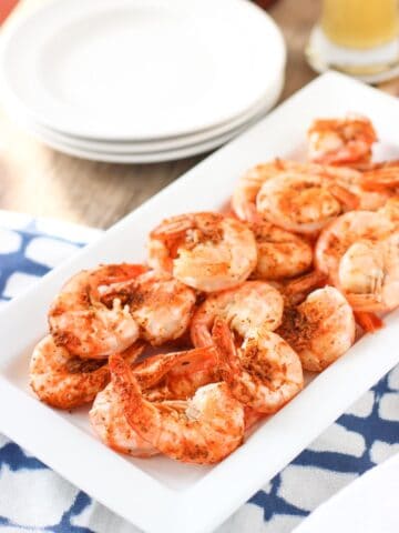 Steamed tail- and shell-on shrimp on a rectangular tray.