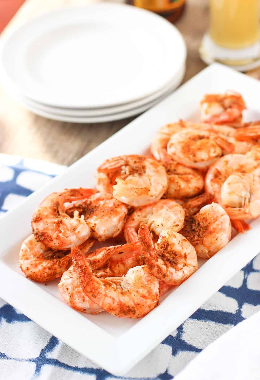 Steamed and seasoned tail- and shell-on shrimp on a tray.