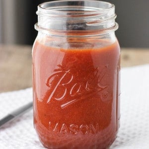 A large glass jar filled with maple bourbon BBQ sauce.